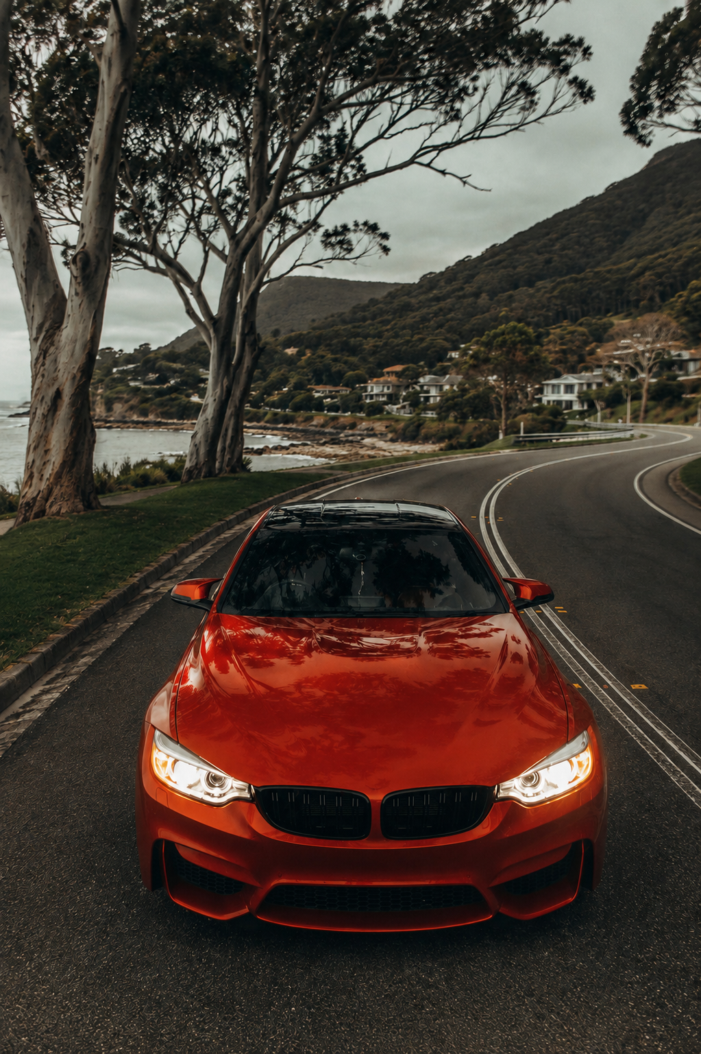 Red European vehicle on a coastal road